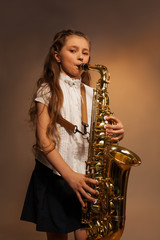 Obraz premium View of girl with long hair playing alto saxophone