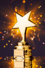 gold star trophy against shiny sparks background
