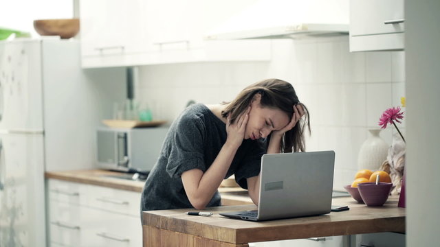 Tired businesswoman with laptop having headache 
