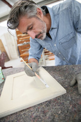 Carpenterin workshop painting wood furniture