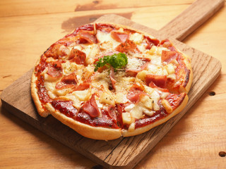 Hawaiin pizza on wood plate