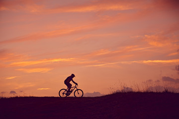 Obraz na płótnie Canvas Mann mit Mountainbike fahren Sonnenaufgang