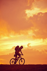 Mann Mountainbike Sonnenaufgang fahrend
