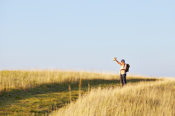Mann mit Cap und St&ouml;cken laufend