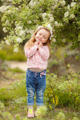 Portrait of little girl outdoors in a lush garden.
