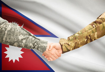 Men in uniform shaking hands with flag on background - Nepal