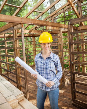 Confident Architect Holding Blueprint In Wooden Cabin