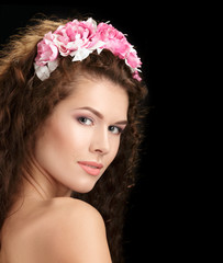 Portrait of a beautiful spring girl wearing flowers wreath.