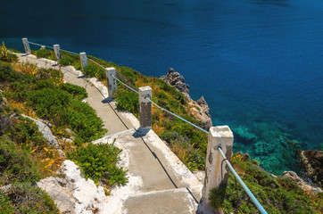 Typical Greek white stairs leading to divers bay on Greek coast