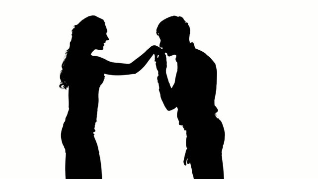 Silhouette of man kissing woman's hand. Slow motion. Close up
