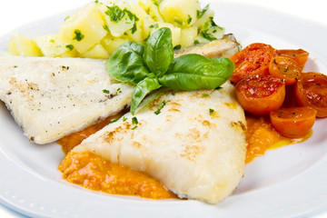 white dish of Fresh black cod with potatoes and tomatoes sauce