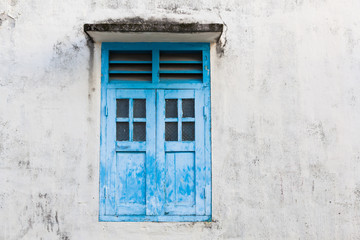Fototapeta na wymiar Blue wooden window and grunge wall
