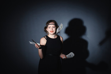 beautiful girl in the studio dressed , retro outfit throws money