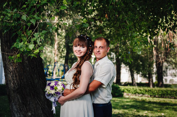 Fototapeta premium wedding couple kissing in green summer park. bride and groom