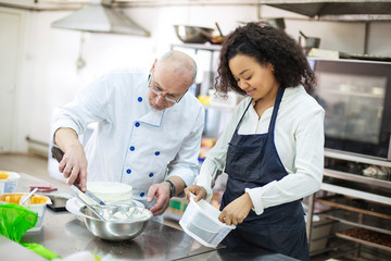 young girl learns to bake cakes with porfessionalnym baker