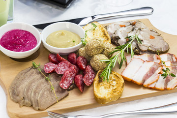 wooden dish with bacon and sausage on a white background