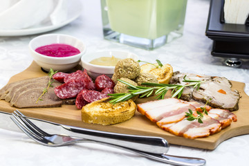 wooden dish with bacon and sausage on a white background