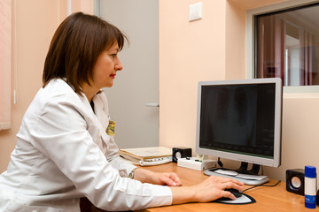 Woman roentgenographer in office clinic is browsing digital imag
