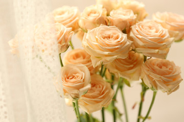 Bouquet of beautiful fresh roses on curtains background