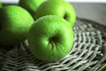 Green apples on wicker mat, closeup