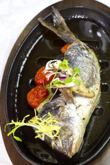 Fried fish dorado with vegetables and lemon