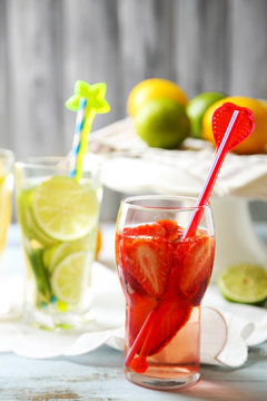 Cocktails with fresh strawberries and lemon lime on wooden background