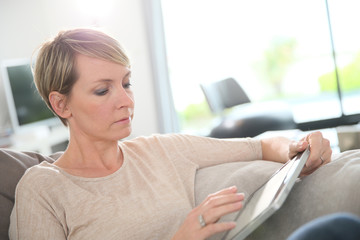 Woman websurfing with digital tablet at home