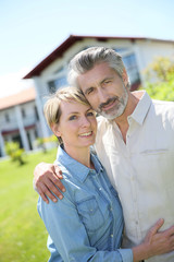 Couple standing in front of newly owned house