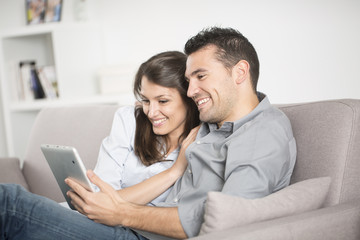 young couple using tablet pc at home
