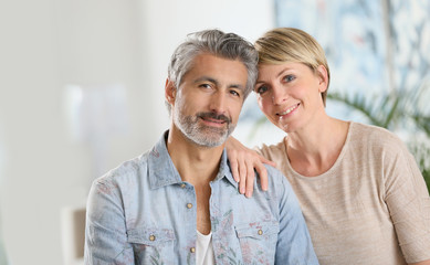 Smiling mature couple standing in contemporary home