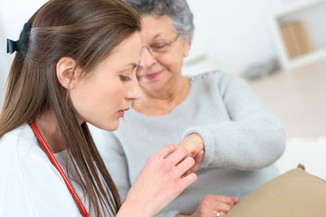 Doctor checking an elderly lady's hand