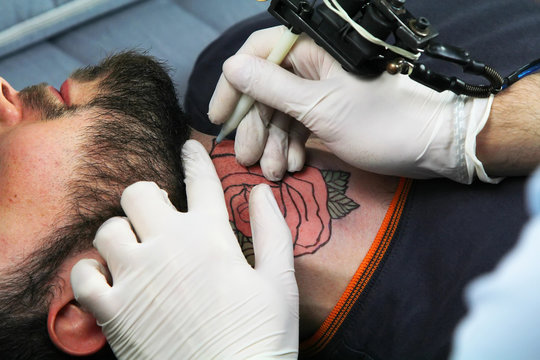 tattooer showing process of making a tattoo 