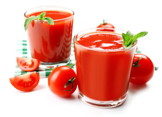 Glasses of fresh tomato juice on checkered napkin, isolated on white