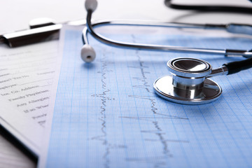 Cardiogram with stethoscope on table, closeup