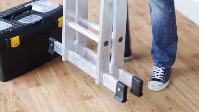 close up of man bringing tool box and ladder