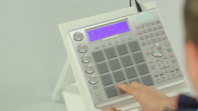 Close up of DJ mixing music on a panel of the midi controller
