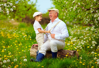 grandson playing with grandpa, pulling the braces, spring garden
