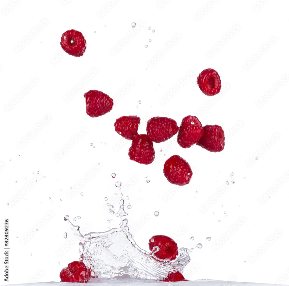 Wall mural Raspberries in water splash on white backround