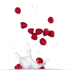 Raspberries in water splash on white backround