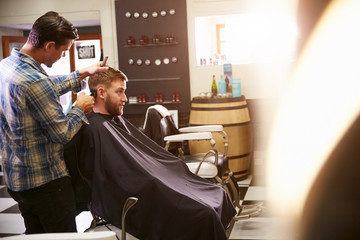 Male Barber Giving Client Haircut In Shop