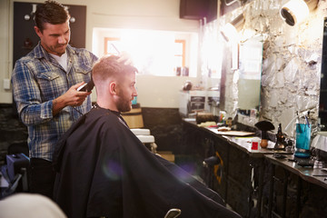 Male Barber Giving Client Haircut In Shop