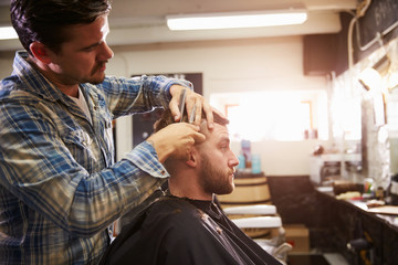 Male Barber Giving Client Haircut In Shop