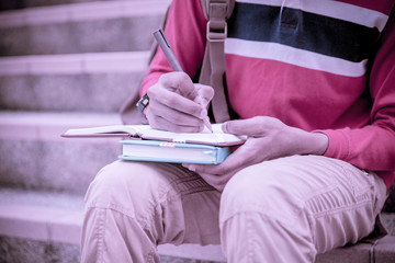 young college student reading book on stairs