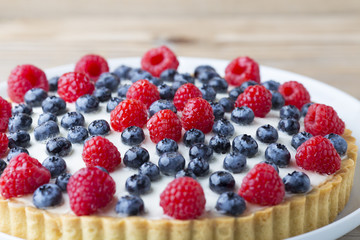 Cake with blueberries and raspberries. Confectionery product.