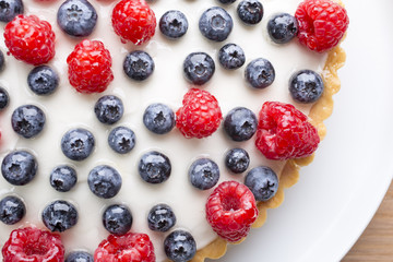 Cake with blueberries and raspberries. Confectionery product.