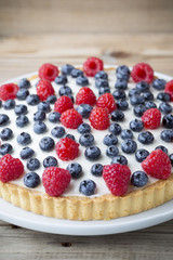 Cake with blueberries and raspberries. Confectionery product.
