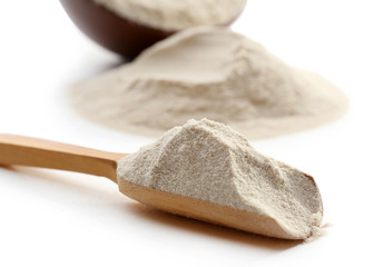 Flour in bowl and wooden spoon isolated on white