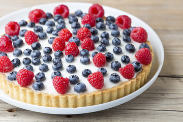Cake with blueberries and raspberries. Confectionery product.