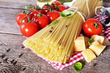 Pasta with cherry tomatoes and other ingredients on wooden table background