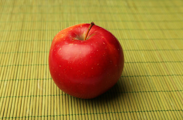Apple on color bamboo mat background